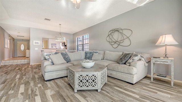 living room with ceiling fan and light hardwood / wood-style flooring