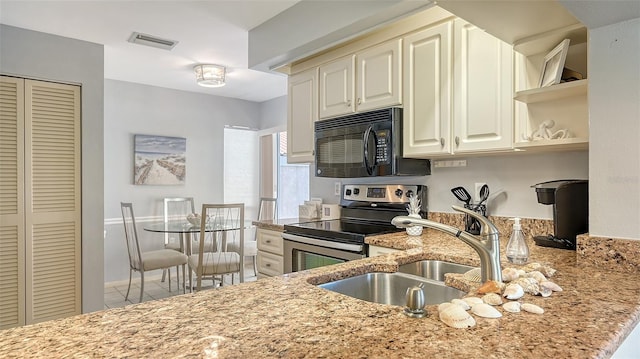 kitchen with light stone counters, stainless steel electric range oven, and sink