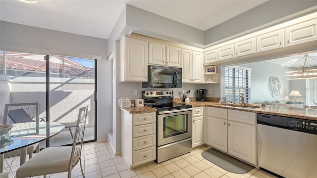 kitchen with light stone countertops, sink, light tile patterned floors, and stainless steel appliances