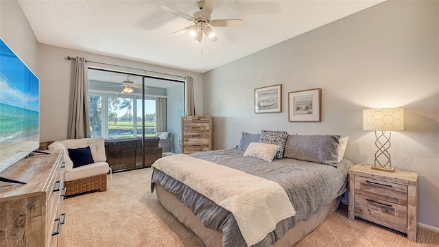 carpeted bedroom featuring ceiling fan and a textured ceiling