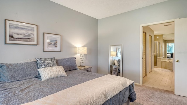 bedroom with ensuite bath and carpet floors