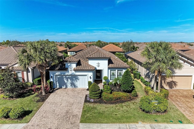 mediterranean / spanish-style home with a garage and a front lawn