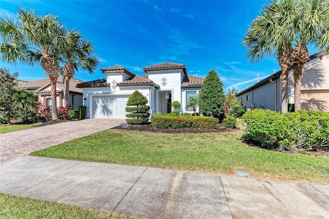 mediterranean / spanish-style house featuring a front yard and a garage