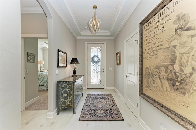 foyer entrance featuring crown molding and a notable chandelier