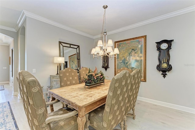 dining room featuring light hardwood / wood-style floors, crown molding, and a chandelier