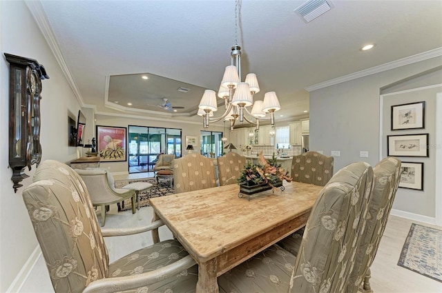 dining room featuring light hardwood / wood-style floors, ceiling fan with notable chandelier, and ornamental molding