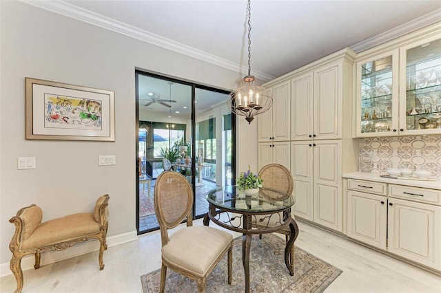 dining area with ceiling fan with notable chandelier, light hardwood / wood-style floors, and ornamental molding