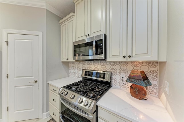 kitchen featuring backsplash, crown molding, cream cabinetry, light stone counters, and stainless steel appliances