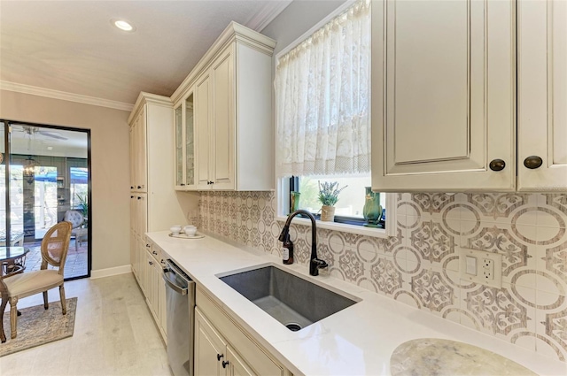 kitchen featuring dishwasher, sink, ornamental molding, light wood-type flooring, and tasteful backsplash