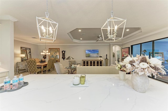 dining area with a raised ceiling, ceiling fan, and crown molding