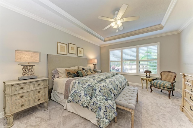 carpeted bedroom with ceiling fan, a raised ceiling, and ornamental molding