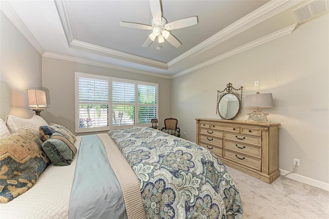 carpeted bedroom featuring a tray ceiling, ceiling fan, and crown molding