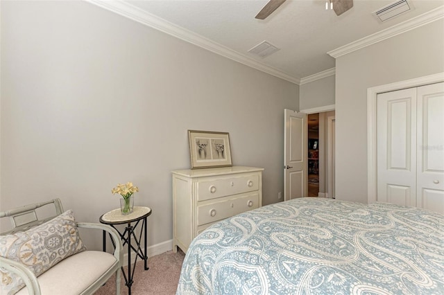 bedroom featuring ceiling fan, light colored carpet, ornamental molding, and a closet