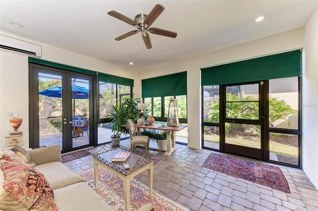 sunroom with a wall mounted air conditioner, french doors, and ceiling fan