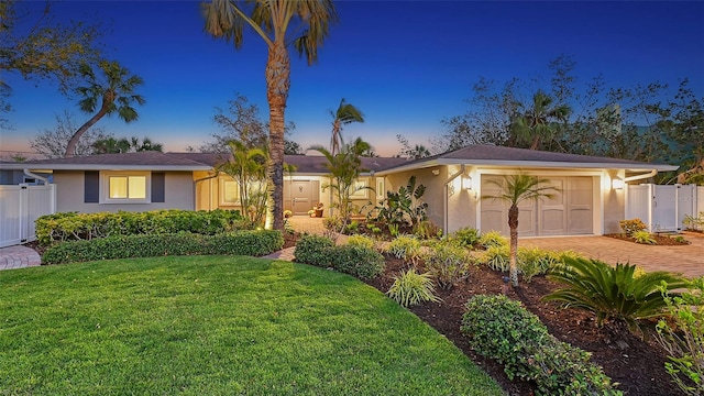 ranch-style house featuring a yard and a garage