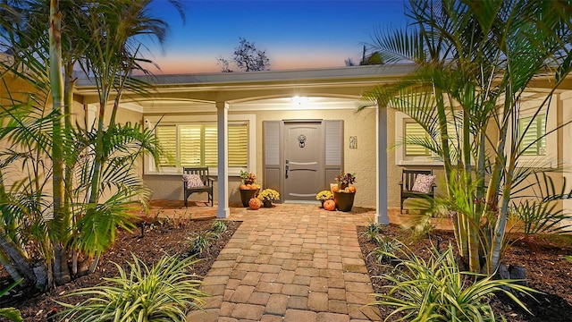 exterior entry at dusk featuring covered porch