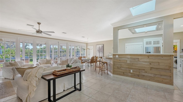 tiled living room featuring french doors, washer / clothes dryer, ceiling fan, and a healthy amount of sunlight