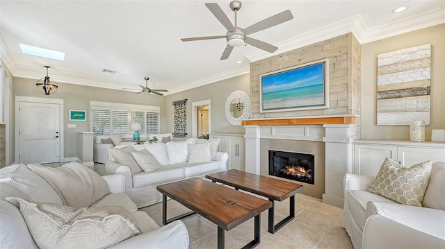 tiled living room featuring a large fireplace, ceiling fan, and ornamental molding