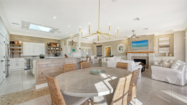 dining room featuring ceiling fan with notable chandelier, beverage cooler, crown molding, sink, and light tile patterned flooring