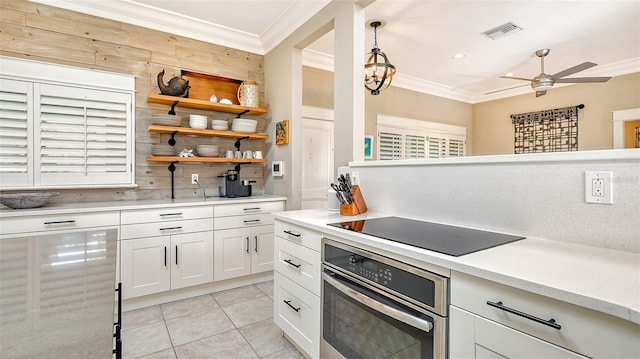 kitchen featuring oven, hanging light fixtures, black electric cooktop, tasteful backsplash, and white cabinetry