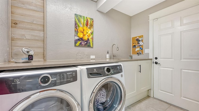 laundry area with cabinets, sink, separate washer and dryer, and light tile patterned flooring