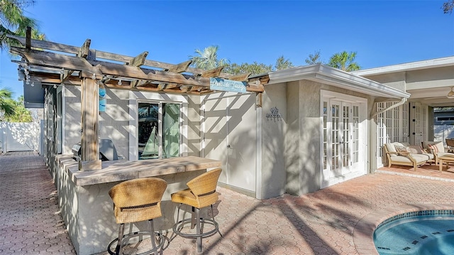 view of patio with a pergola, exterior bar, and french doors