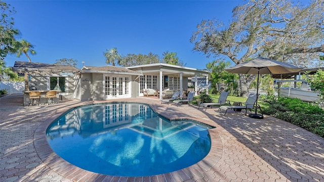 view of swimming pool with french doors and a patio