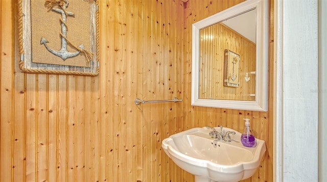 bathroom with wooden walls and sink