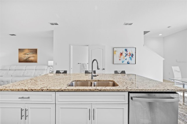 kitchen featuring dishwasher, light stone counters, white cabinetry, and sink