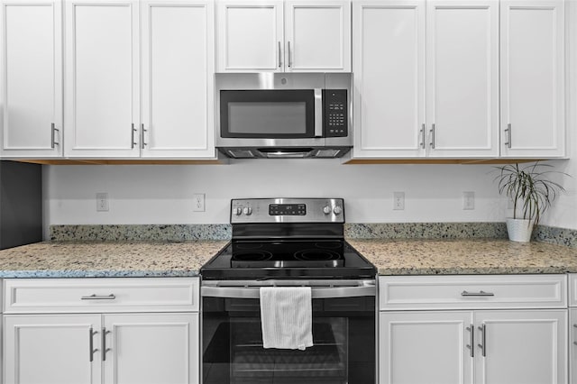 kitchen with white cabinets, stainless steel appliances, and light stone countertops