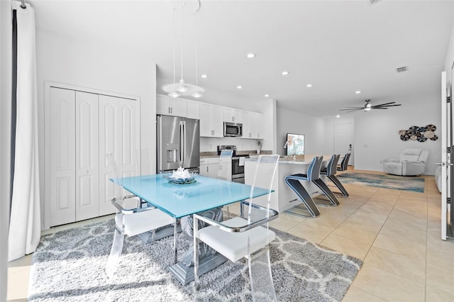 dining space with ceiling fan and light tile patterned flooring