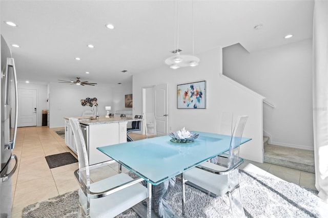 dining space featuring light tile patterned floors, ceiling fan, and sink