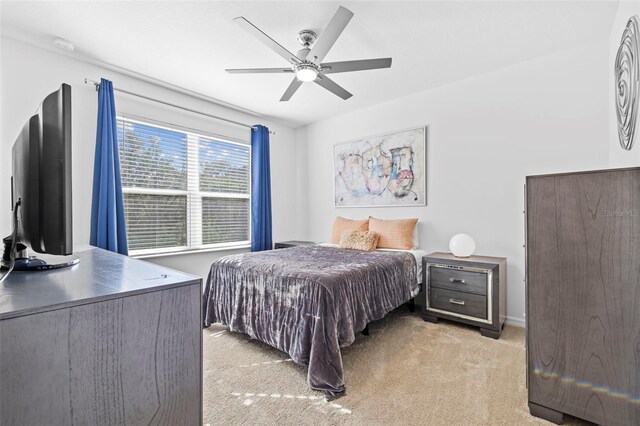 bedroom featuring ceiling fan and light carpet