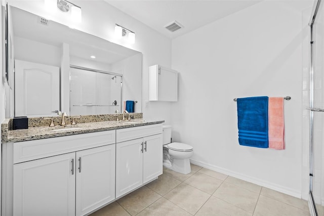 bathroom with toilet, a shower with door, vanity, and tile patterned flooring