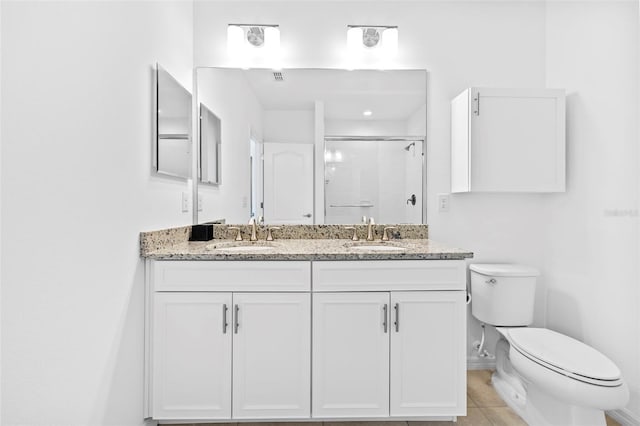 bathroom featuring toilet, tile patterned flooring, vanity, and walk in shower