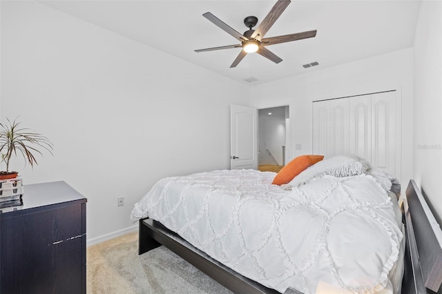 carpeted bedroom with ceiling fan and a closet