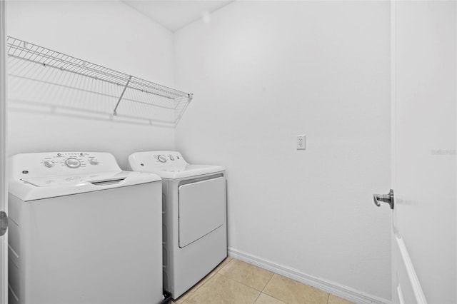 laundry room with light tile patterned floors and washing machine and clothes dryer