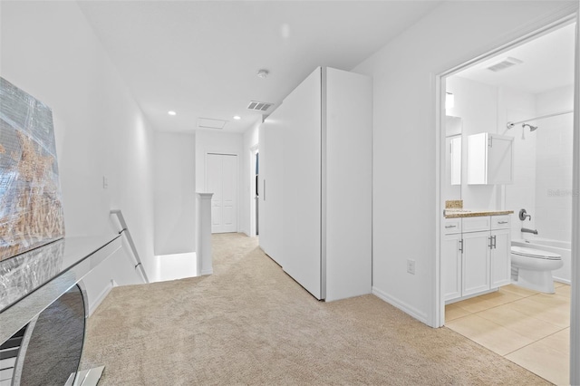 hallway featuring light colored carpet