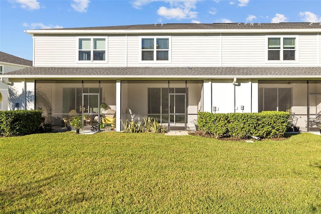 rear view of property featuring a lawn and a sunroom