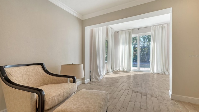 sitting room with ornamental molding and light wood-type flooring