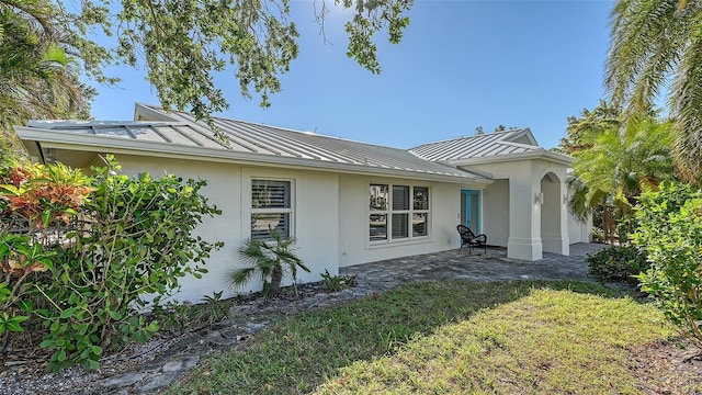 rear view of property with a yard and a patio area