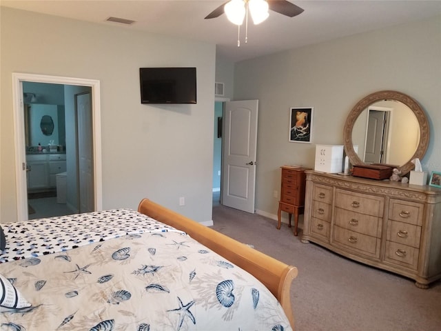 bedroom featuring ensuite bathroom, ceiling fan, and light colored carpet