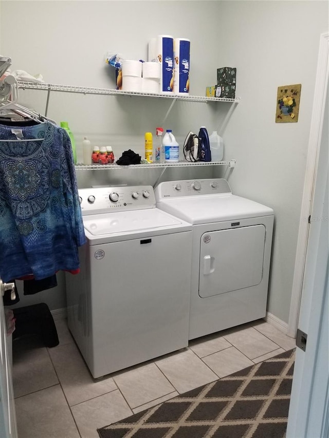 laundry room featuring washer and clothes dryer and light tile patterned flooring