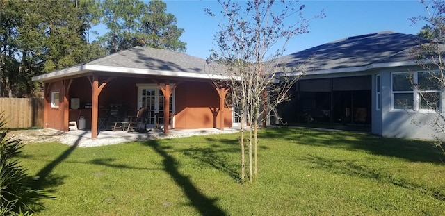 back of house featuring a lawn and a patio area