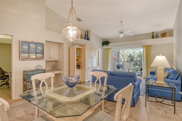 dining room featuring ceiling fan, light hardwood / wood-style floors, and vaulted ceiling