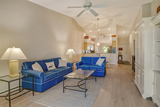 living room with light hardwood / wood-style floors, vaulted ceiling, and ceiling fan