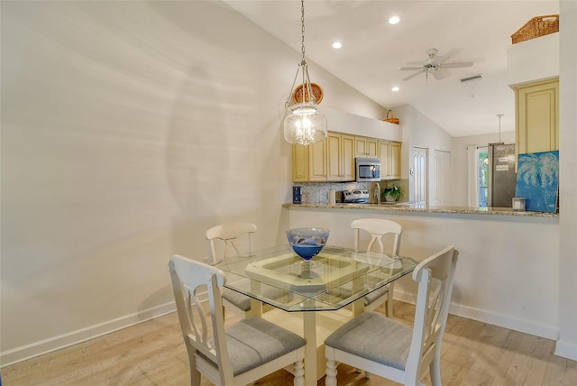 dining area with high vaulted ceiling, light hardwood / wood-style flooring, and ceiling fan