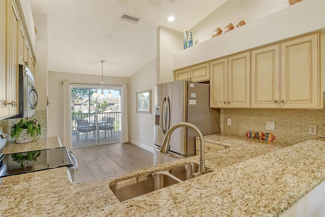 kitchen featuring sink, hanging light fixtures, tasteful backsplash, light hardwood / wood-style flooring, and high vaulted ceiling