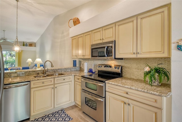 kitchen featuring sink, light hardwood / wood-style flooring, cream cabinetry, and appliances with stainless steel finishes