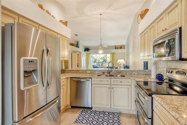 kitchen featuring kitchen peninsula, decorative backsplash, stainless steel appliances, sink, and light hardwood / wood-style floors